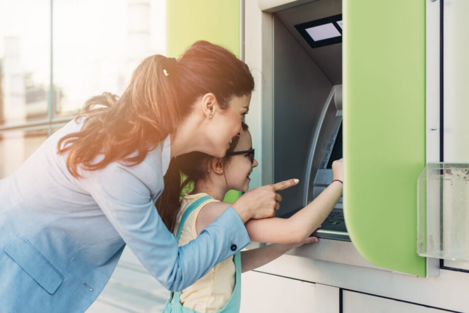 Mutter mit Tochter am Geldautomaten